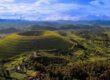 Aerial view of a lush volcanic crater surrounded by green farmlands in Uganda.